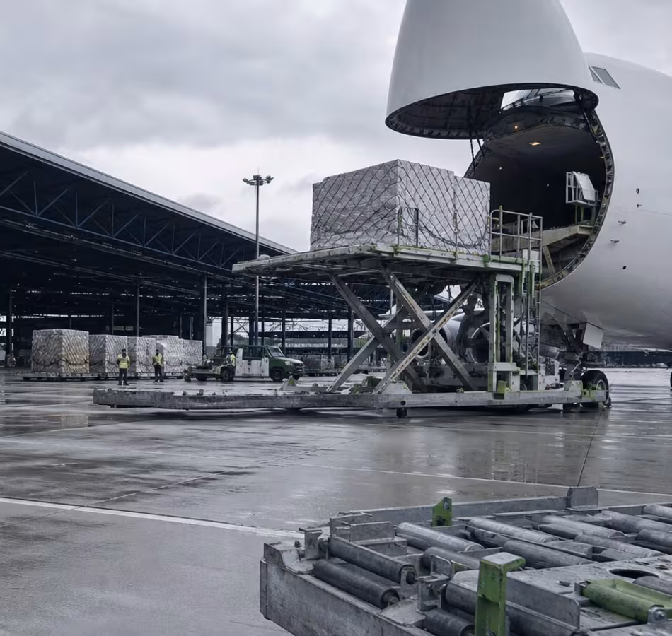 Cargo aircraft with its nose door open and a pallet on a loading platform